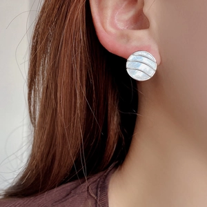 Close-up of S925 sterling silver geometric earring with striped white shell inlay