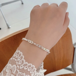 Macro detail of S925 sterling silver chain bracelet with intricate flower pattern engravings