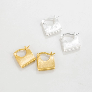 Macro view of S925 sterling silver earrings showing matte brushed texture and S925 hallmark
