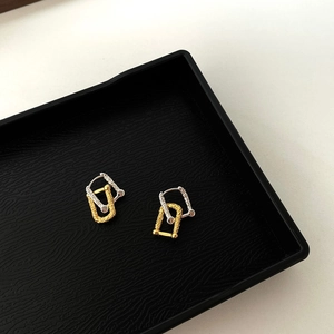 Détail de boucles d'oreilles fer à cheval en argent 925 bicolore avec texture martelée