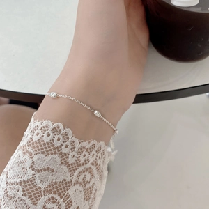 Gros plan d'un bracelet en argent sterling S925 porté au poignet avec dentelle fine