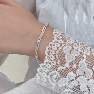 Detailed shot of S925 sterling silver chain bracelet featuring floral embossed links