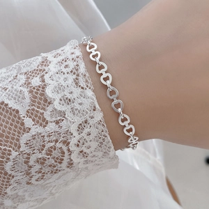 Minimalist S925 sterling silver hollow heart link bracelet worn with lace sleeve