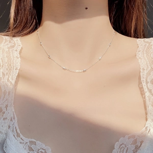 Close-up of minimalist S925 sterling silver chain with small beads on a female neck
