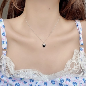 Elegant S925 sterling silver necklace with black heart pendant worn by a model