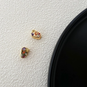 Macro shot of 925 silver cheese-shaped gold earrings with colorful zircon gemstones