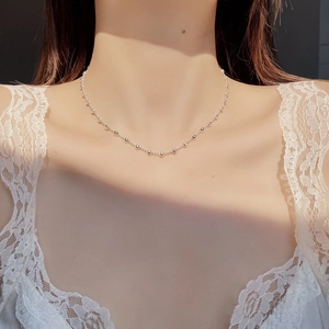Macro detail of S925 sterling silver beaded necklace on model neck with lace dress
