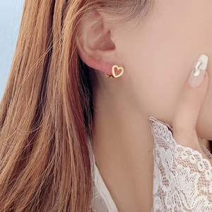 Elegant gold hollow heart earrings on model with S925 sterling silver ear buckle