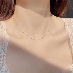 Close-up of S925 sterling silver beaded necklace worn on neck with white lace background
