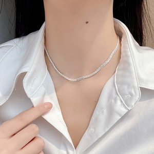 Detail of S925 sterling silver braided twist necklace on model neck with white shirt