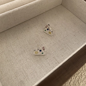 Macro view of 925 sterling silver heart earrings with colorful zircon stones