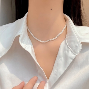 Close-up of minimalist S925 sterling silver twisted rope chain necklace on white silk cloth