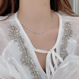 Close-up of S925 sterling silver beaded necklace worn on a neck with a white chiffon top