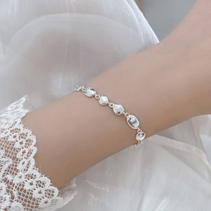 Close-up of polished S925 sterling silver bean link bracelet worn on a female wrist