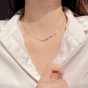 Detail of S925 sterling silver chain necklace worn on neck with white silk shirt