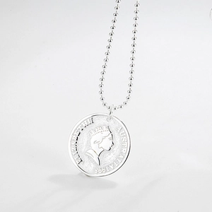 Macro detail of silver 925 coin necklace featuring Queen Elizabeth II profile and ball chain