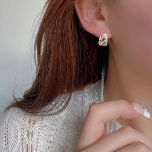 Vintage gold oval earrings with colorful zircon gemstones worn by a model