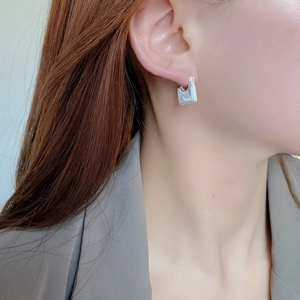Close-up of minimalist S925 sterling silver U-shaped hoop earring with matte finish