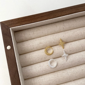 Detail of 925 silver star and moon stud earrings with a matte texture in a velvet box