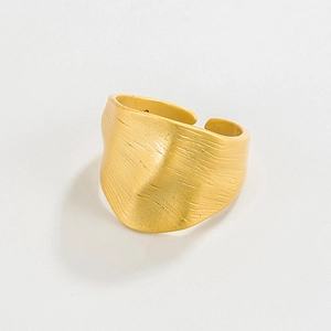 Macro detail of wide matte gold adjustable ring with unique crushed texture surface