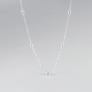 Détail du collier en argent 925 minimaliste avec cinq perles métalliques ovales lisses