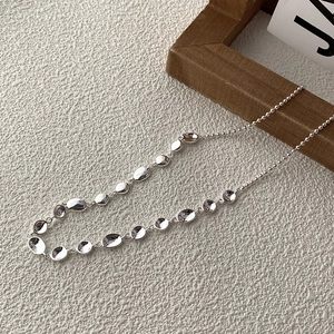 Collana d'argento con ciondolo a pisello irregolare e catena a sfere su sfondo bianco art