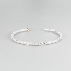 Detail showing vintage embossed floral motifs and gold accent bead on S925 silver bangle