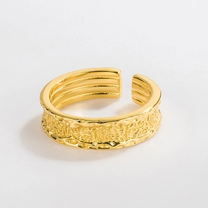 Detailed view of an adjustable gold-plated ring featuring unique hammered lava texture
