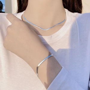 Close-up of minimalist S925 sterling silver herringbone snake chain bracelet on a model