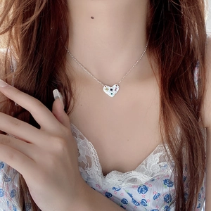 Collier coeur en argent S925 avec zircons colorés sur un mannequin en robe fleurie en dentelle