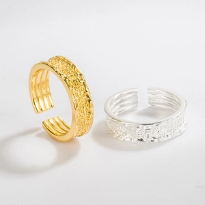 Close-up of S925 silver rings with embossed relief texture in gold and silver finish