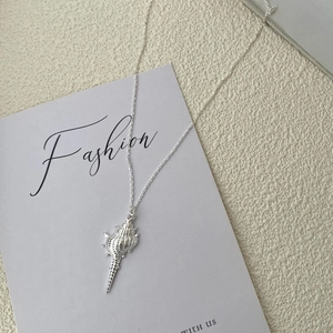 Detailed view of S925 sterling silver conch shell pendant on a thin link chain necklace