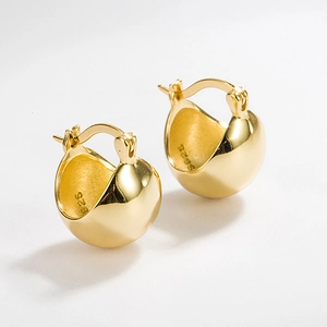 Close-up of golden S925 sterling silver ball earrings with smooth mirror finish detail
