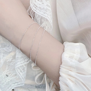 Nahaufnahme von dreilagigen 925 Sterling Silber Perlenarmbändern am Handgelenk