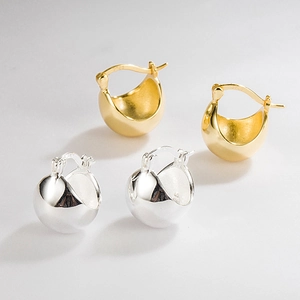 Macro shot of 925 sterling silver ball earrings in gold and silver with S925 hallmark