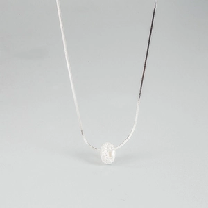 Gros plan sur la chaîne serpent en argent S925 avec pendentif donut effet givré
