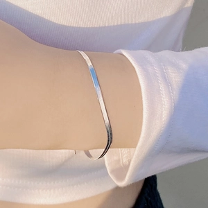 Minimalist S925 sterling silver flat snake chain bracelet worn on a female wrist