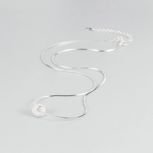 Détail du pendentif donut en argent S925 sablé sur une chaîne serpent minimaliste