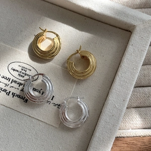 Dettaglio macro di orecchini a cerchio a spirale a tre strati in argento e oro