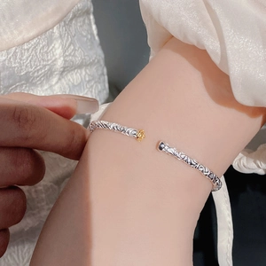 S925 sterling silver open bangle with embossed totems and a small golden rose accent