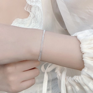 Nahaufnahme eines dreilagigen Armbands aus 925 Sterling Silber an einem Handgelenk