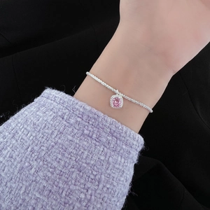 Gros plan d'un bracelet en argent S925 avec une pierre rose carrée et entourage diamant