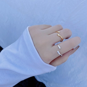 Close-up of minimalist S925 sterling silver teardrop rings in gold and silver finishes