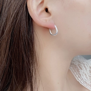 Close-up of vintage S925 sterling silver wheat pattern twisted hoop earrings on model