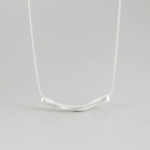Close-up of minimalist 925 silver necklace with a matte brushed finish geometric pendant