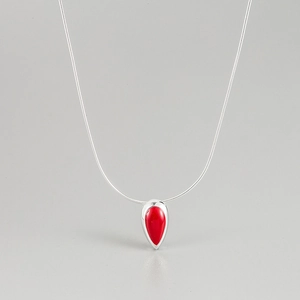 Détail du pendentif goutte rouge sur une chaîne serpent en argent au design minimaliste