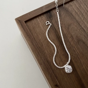 Gros plan du bracelet en argent S925 avec pendentif carré et détails en zircons brillants