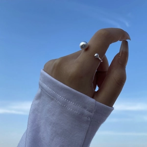 Detail of S925 sterling silver brushed ball ring with adjustable open band on hand