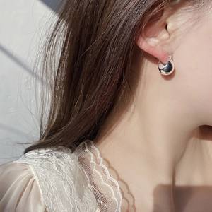 Close-up of minimalist 925 silver stud earrings with polished dome ball design on ear