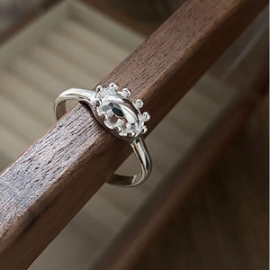 Macro detail of S925 sterling silver ring with crown setting and opal-like gemstone